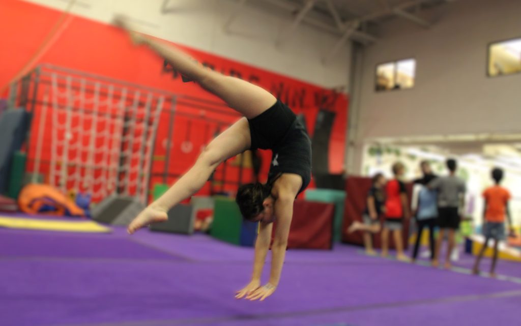 A child doing a back flip at a tumbling clinic in Chandler Az